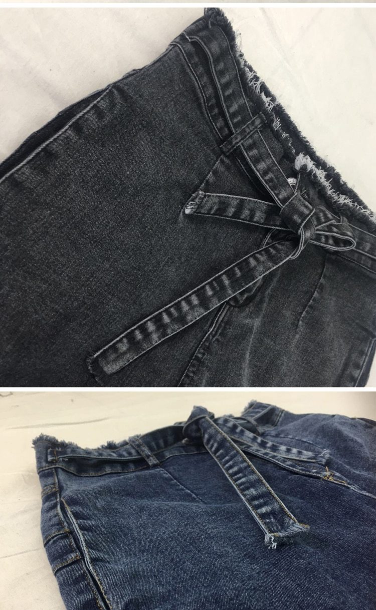 Close-up of fringed hem detail on women’s denim
